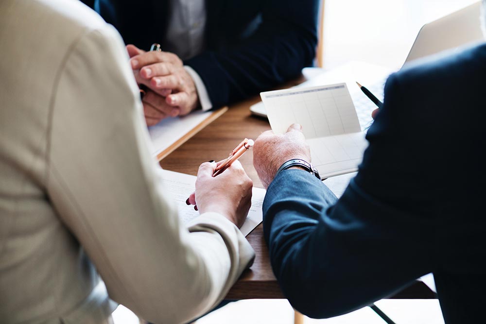 Closeup of 3 people working at a conference table in a business setting