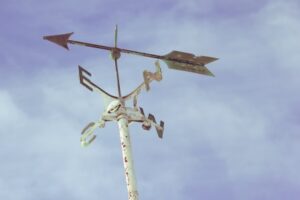 A weathervane with blue sky in the background.